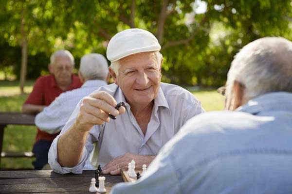 Two seniors enjoying playing chess at retirement home